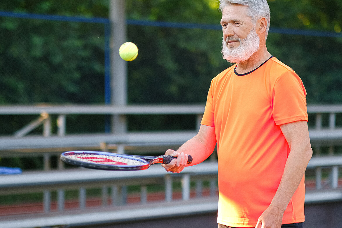 Man bouncing tennis ball on racket