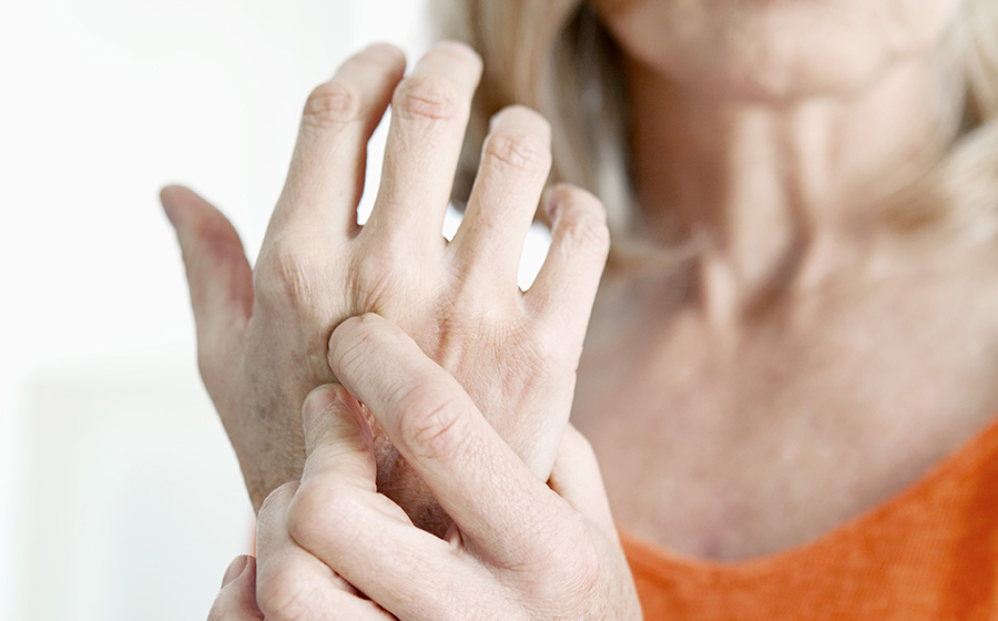 woman holding arthritic hand in pain