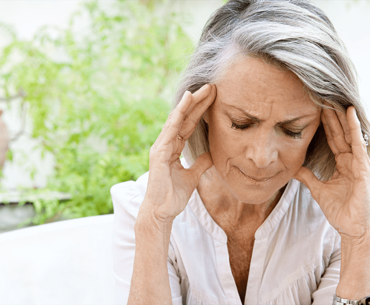 Woman with a migraine holding her head