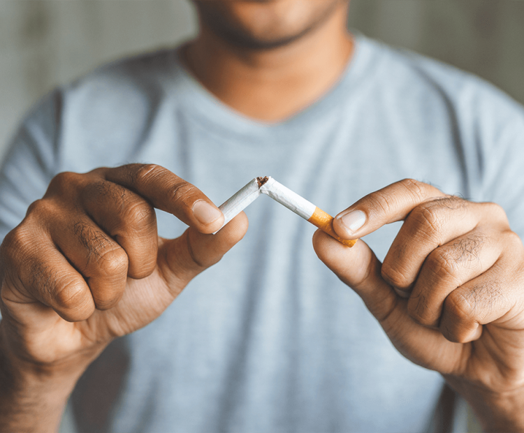 Man breaking cigarette in half