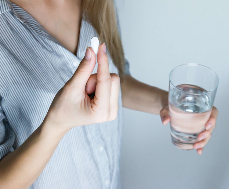 Woman taking ibuprofen pill