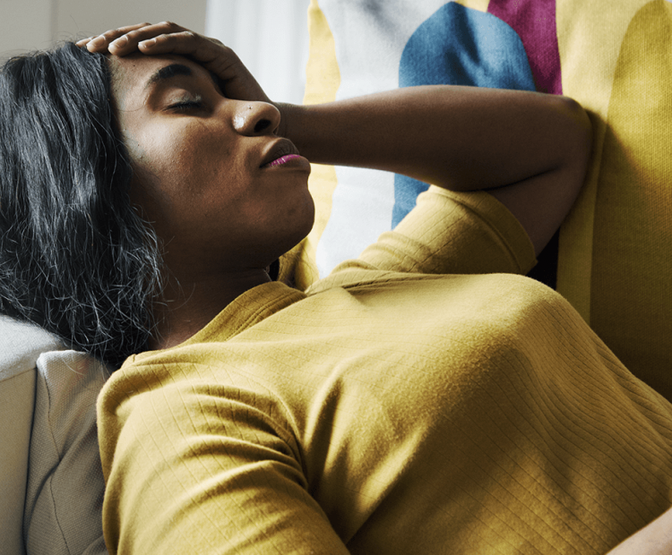 Woman in pain lying on couch 