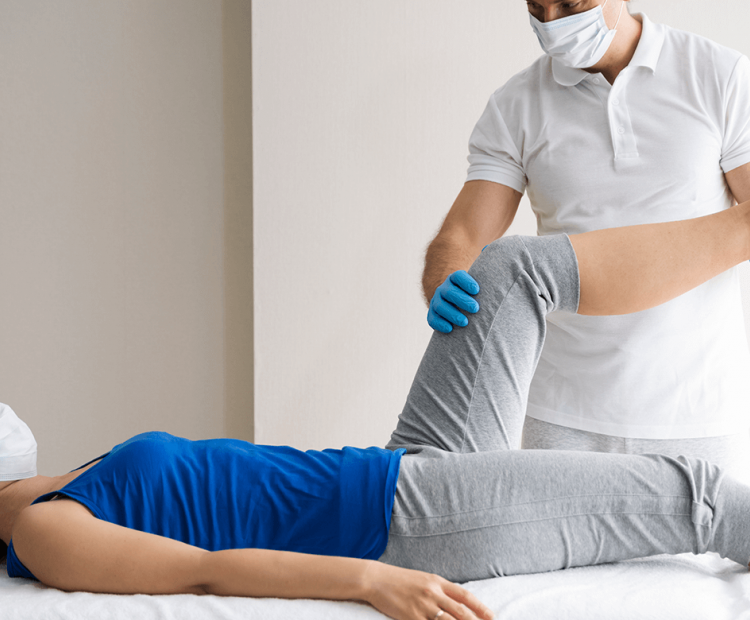 Physical therapist stretching a patient's leg