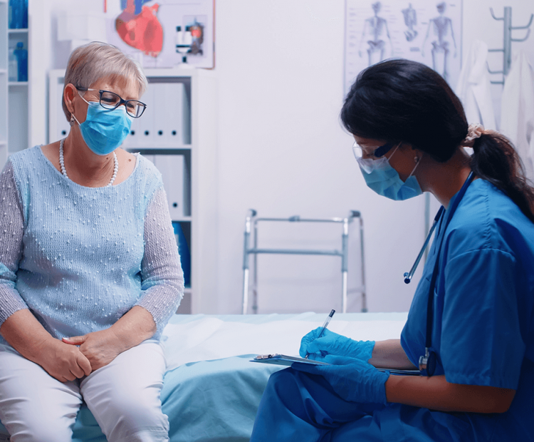 Nurse and patient wearing masks in exam room