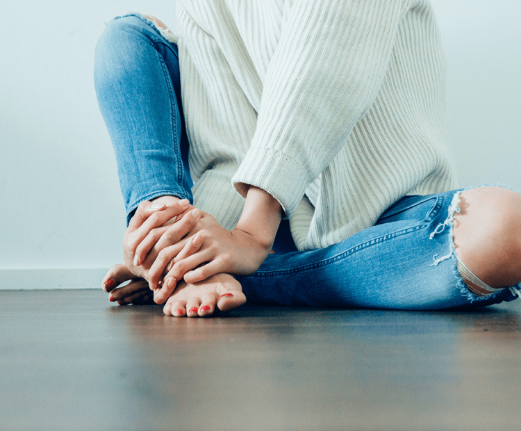 Woman holding her feet in pain