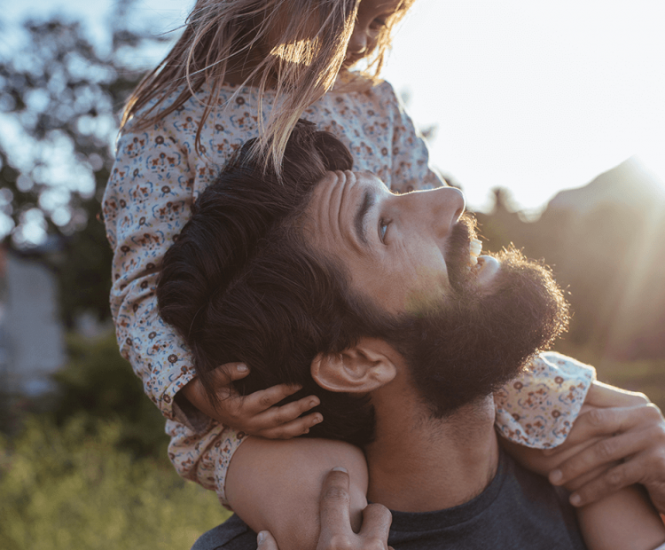 Man carrying daughter on shoulders