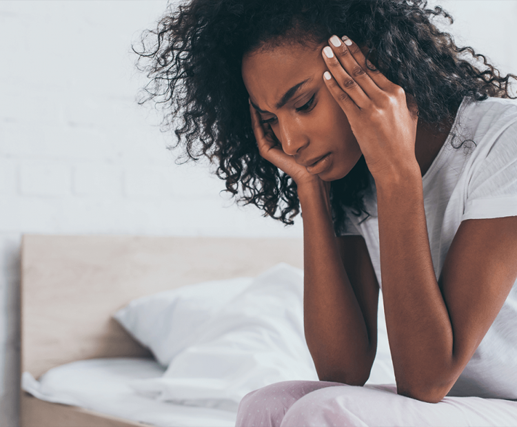 Woman with headache rubbing her temples