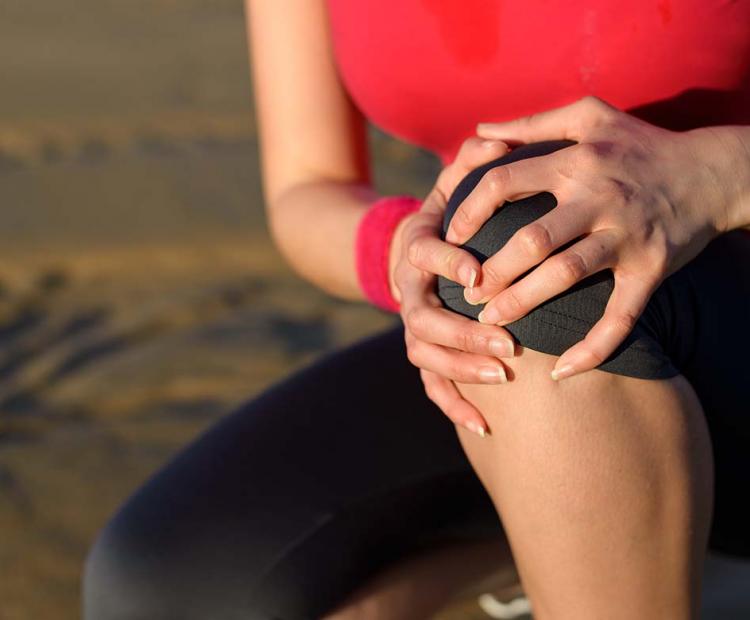 Woman holding sore knee