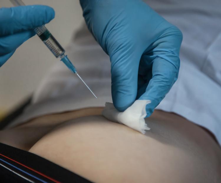 Image of a healthcare professional administering an injection. 