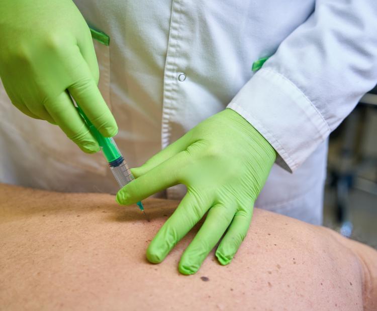 Image of person being injected in the back.