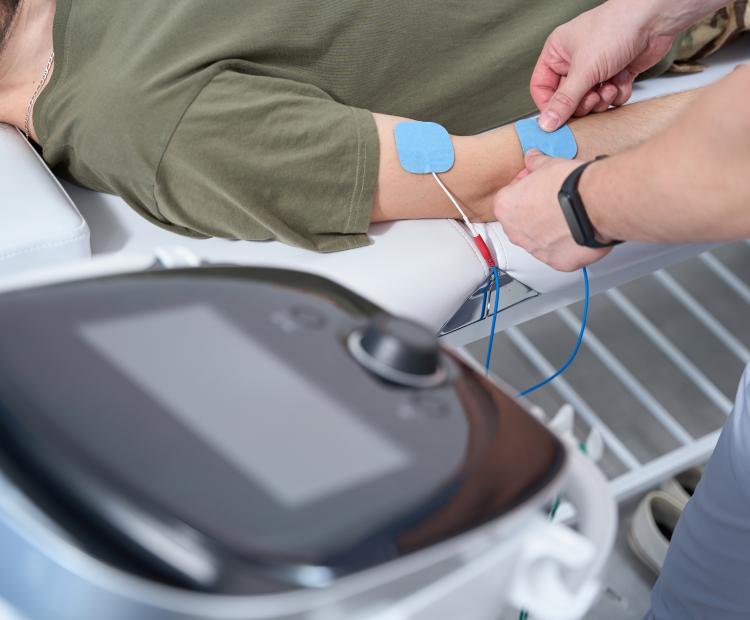 A healthcare professional attaching electrodes for an electrodiagnostic test to a patient. 
