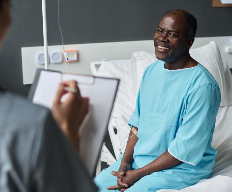 Patient speaking to a healthcare professional after a procedure preparing to be discharged.