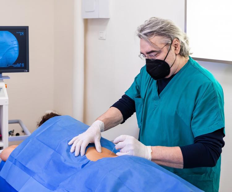 A doctor preparing a patient for a back injection procedure. 