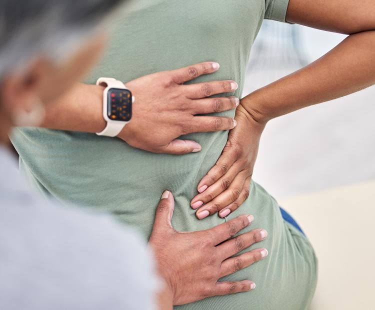 Doctor examining a patient's lower back for source of pain.