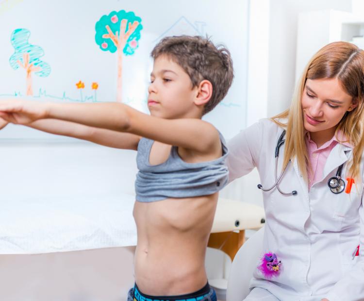 A doctor examining s child's spine.