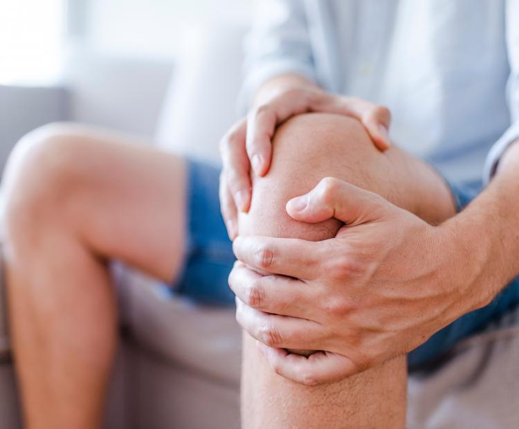 Man holding knee in pain
