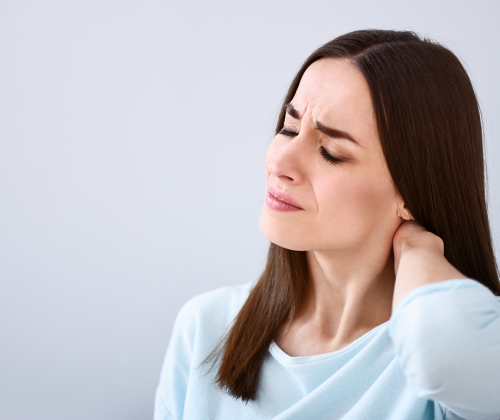 Woman in pain holding back of head