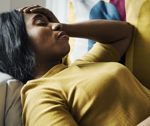 Woman in pain lying on couch 