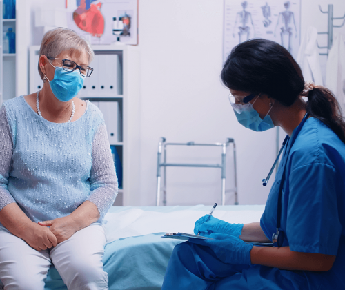 Nurse and patient wearing masks in exam room