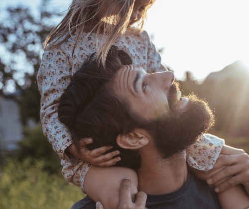 Man carrying daughter on shoulders