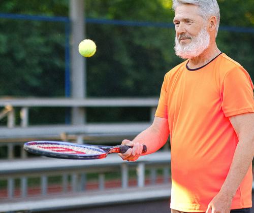 Man bouncing tennis ball on racket
