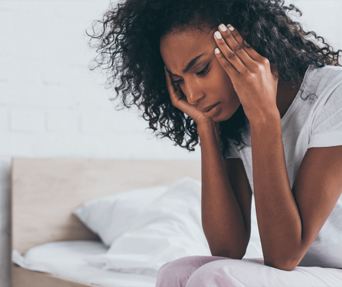 Woman with headache rubbing her temples