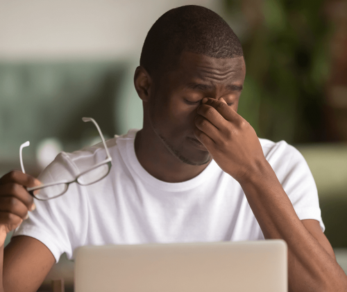 Man rubbing his eyes in pain