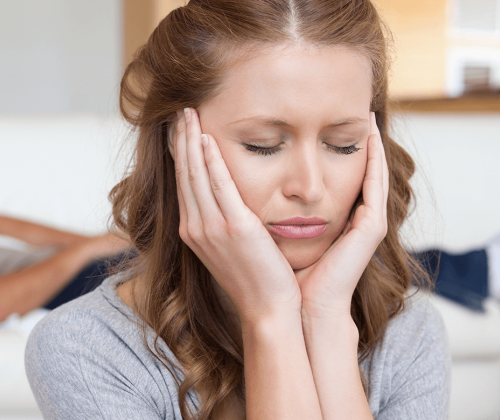 Stressed woman with hands on her head
