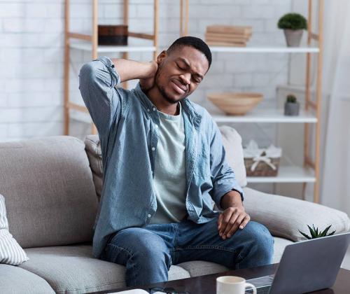 Man with neck pain in front of computer