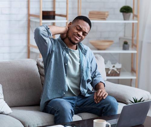 Man with neck pain in front of computer