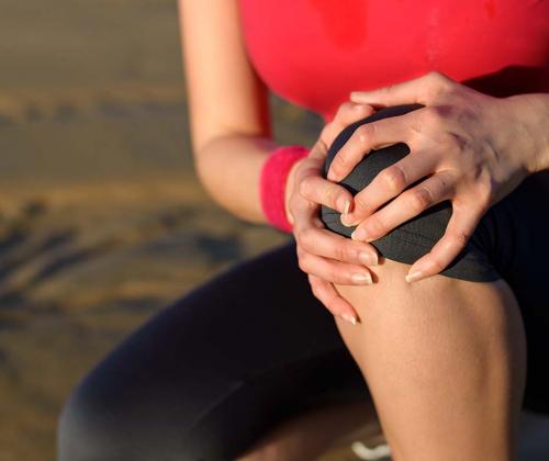 Woman holding sore knee