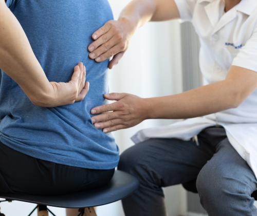 Doctor checking out a patient's back after a facet joint stops working. 