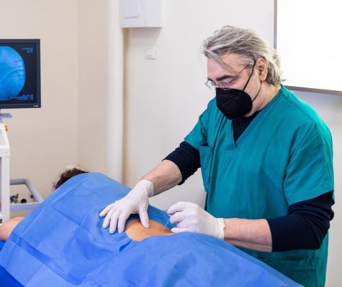 A doctor preparing a patient for a back injection procedure.
