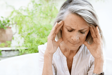 Woman with a migraine holding her head