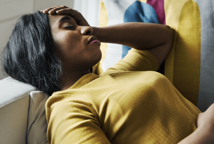 Woman in pain lying on couch 