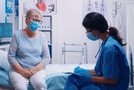 Nurse and patient wearing masks in exam room