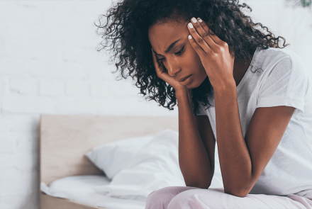 Woman with headache rubbing her temples