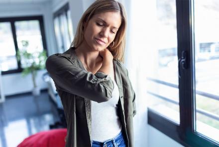 Woman rubbing neck in pain