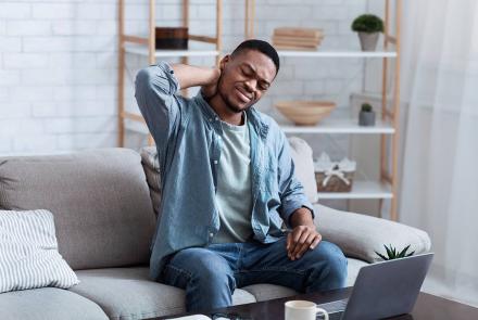Man with neck pain in front of computer