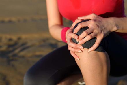 Woman holding sore knee