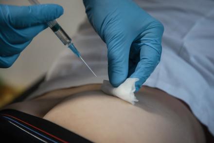 Image of a healthcare professional administering an injection. 