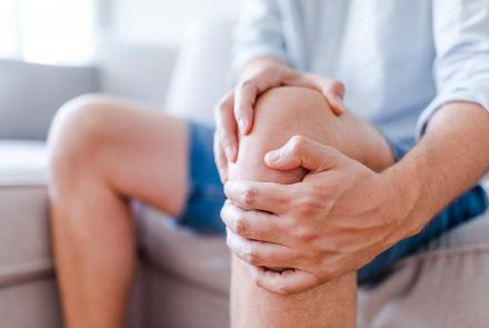 Man holding knee in pain